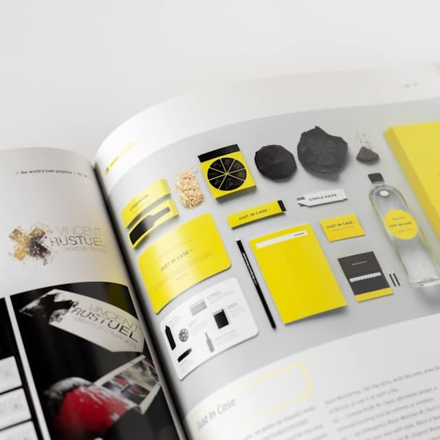 Brand guidelines book open on a page of yellow identity assets