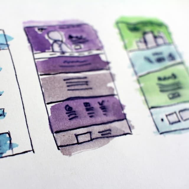 Hand-drawn app screens sketched and coloured on paper