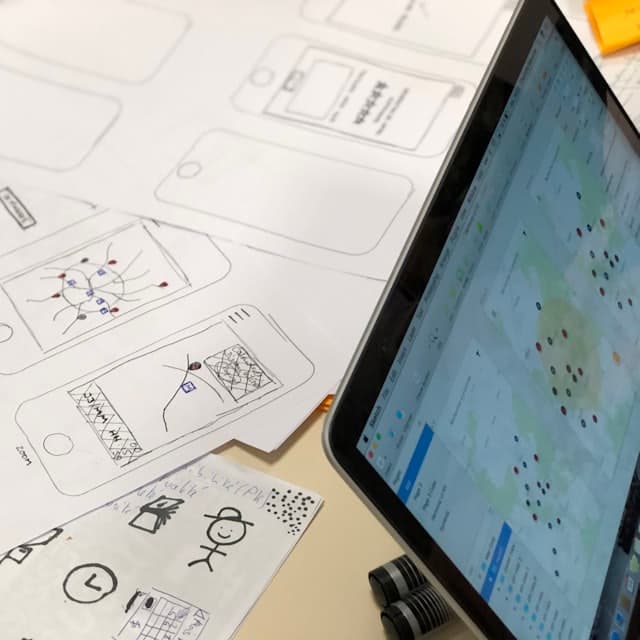 Paper wireframes next to a tablet showing the built screen